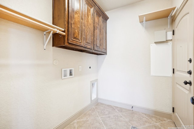 clothes washing area featuring cabinets, light tile patterned floors, washer hookup, and hookup for an electric dryer