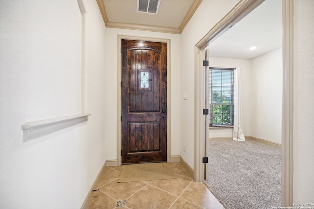 foyer entrance featuring crown molding and light colored carpet