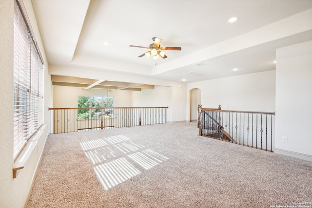 carpeted empty room featuring ceiling fan and a tray ceiling