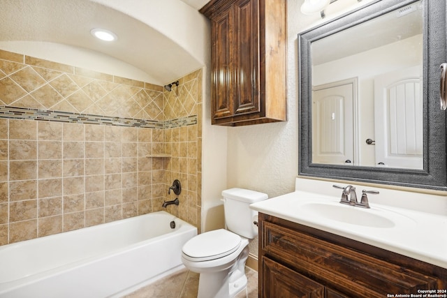 full bathroom featuring tile patterned floors, vanity, tiled shower / bath combo, and toilet