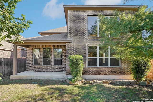 rear view of house with a lawn and a patio