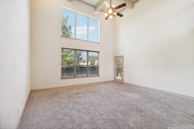 spare room with a high ceiling, carpet floors, and beam ceiling