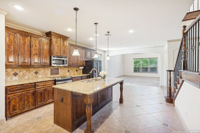 kitchen featuring pendant lighting, a kitchen island with sink, a kitchen breakfast bar, sink, and appliances with stainless steel finishes