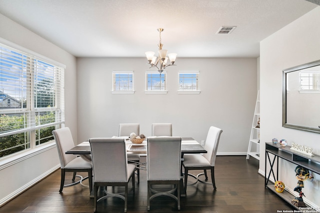 dining area featuring dark hardwood / wood-style flooring and an inviting chandelier