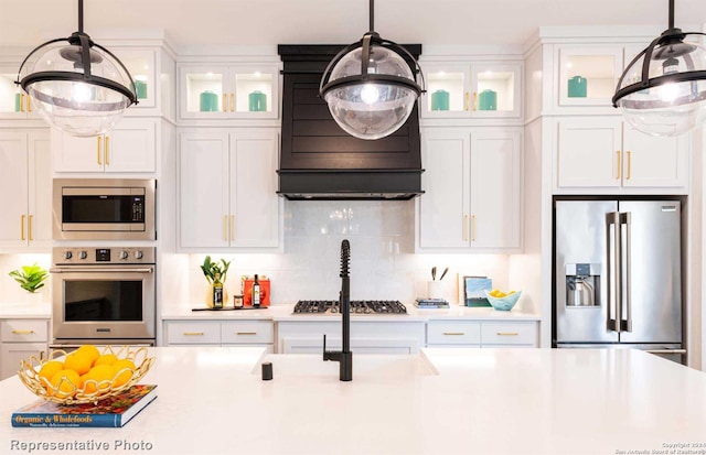 kitchen featuring tasteful backsplash, white cabinetry, pendant lighting, and stainless steel appliances