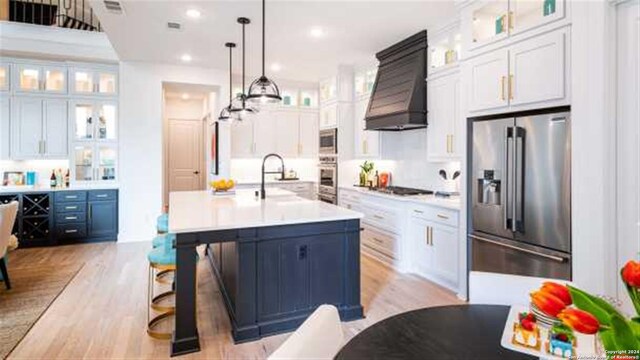 kitchen with white cabinets, decorative light fixtures, stainless steel appliances, and sink