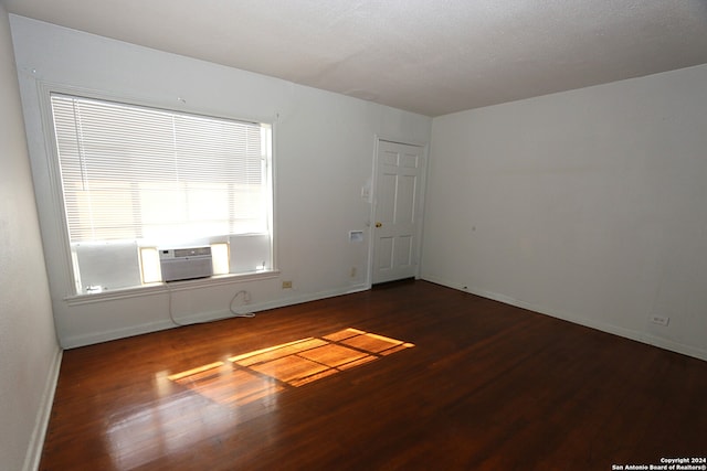 spare room with hardwood / wood-style floors, a textured ceiling, and cooling unit