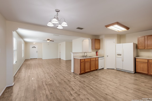 kitchen with sink, pendant lighting, white appliances, and light wood-type flooring