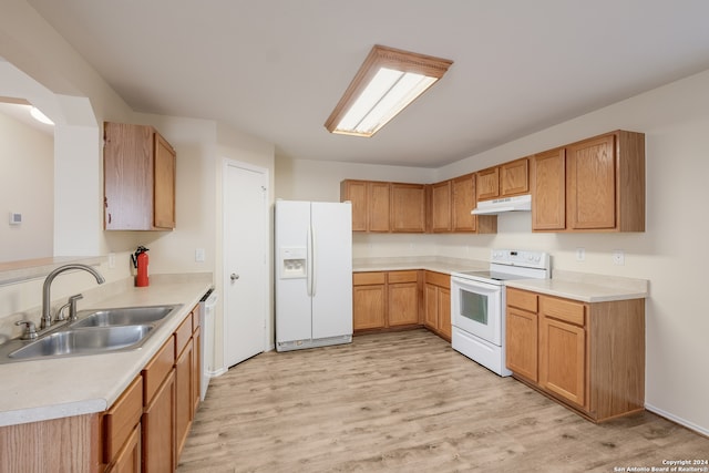 kitchen with light wood-type flooring, white appliances, and sink