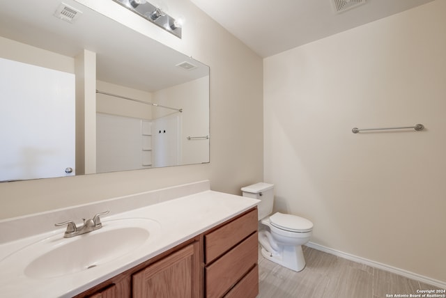 bathroom with vanity, toilet, and a shower