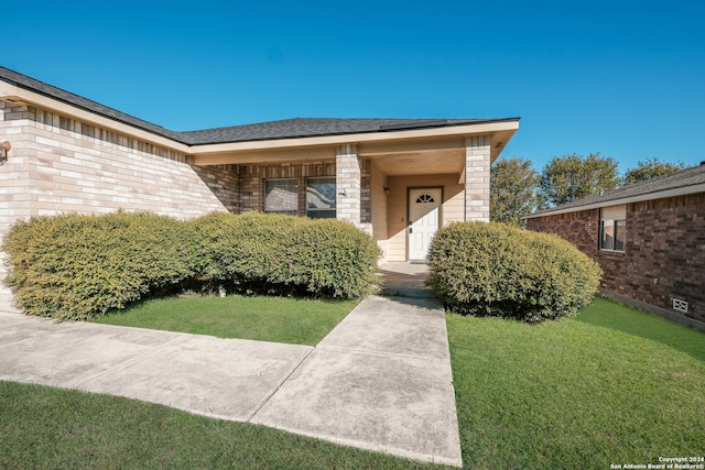 view of exterior entry featuring a yard