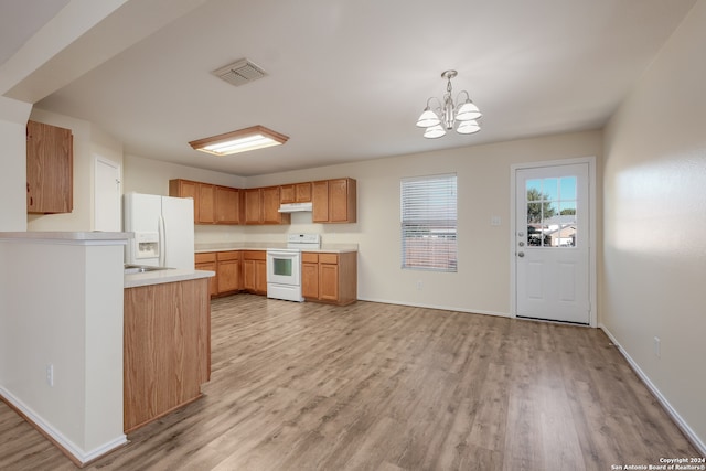 kitchen featuring pendant lighting, light hardwood / wood-style floors, white appliances, and a chandelier