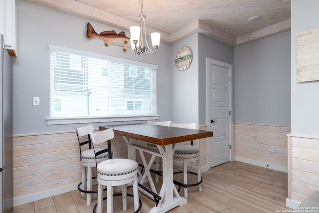 dining space with a chandelier, light hardwood / wood-style floors, wooden walls, and wood ceiling