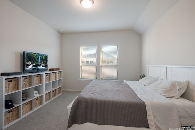 carpeted bedroom with lofted ceiling