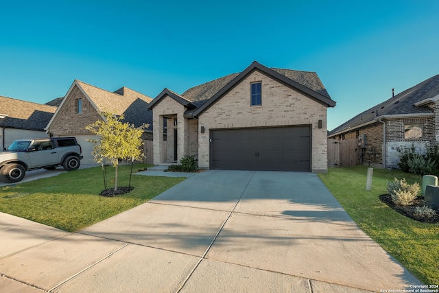 view of front of home featuring a front lawn and a garage