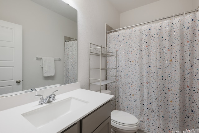 bathroom with vanity, a shower with shower curtain, and toilet