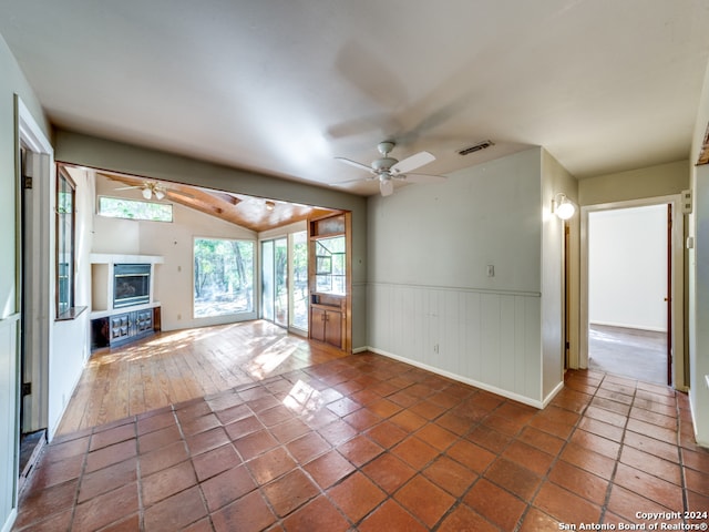 unfurnished living room with ceiling fan and dark tile patterned floors