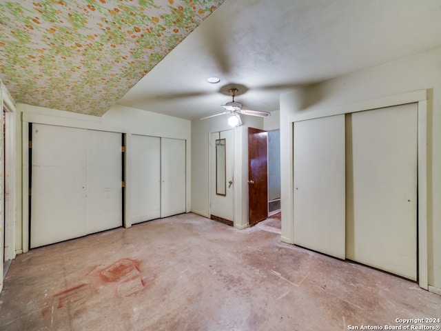 unfurnished bedroom with multiple closets and ceiling fan