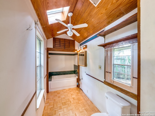 bathroom featuring parquet flooring, wood ceiling, a washtub, vaulted ceiling with skylight, and ceiling fan