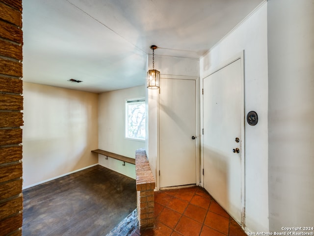 foyer entrance featuring dark tile patterned floors