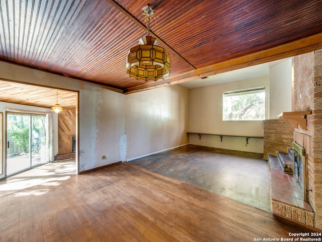 unfurnished living room with hardwood / wood-style floors, wood ceiling, a fireplace, and vaulted ceiling