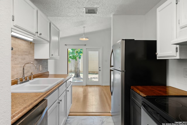 kitchen with white cabinetry, sink, dishwasher, and vaulted ceiling