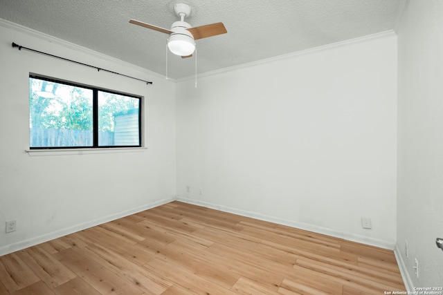 empty room with a textured ceiling, ceiling fan, light hardwood / wood-style floors, and crown molding