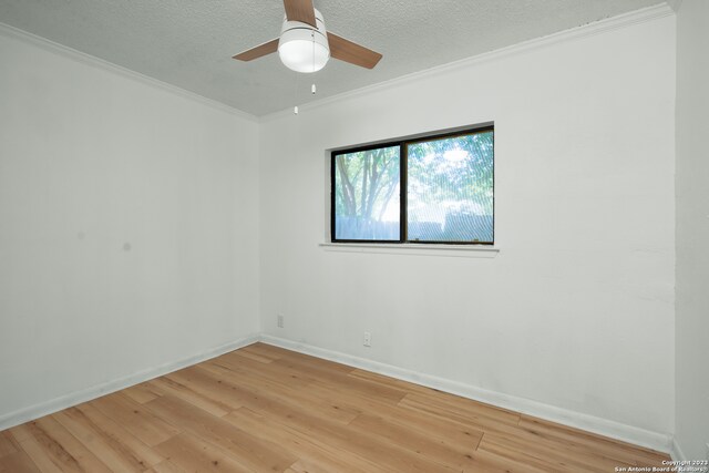 unfurnished room featuring ceiling fan, ornamental molding, a textured ceiling, and light wood-type flooring