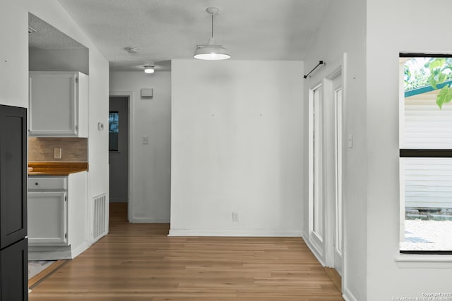 interior space with light wood-type flooring and a textured ceiling