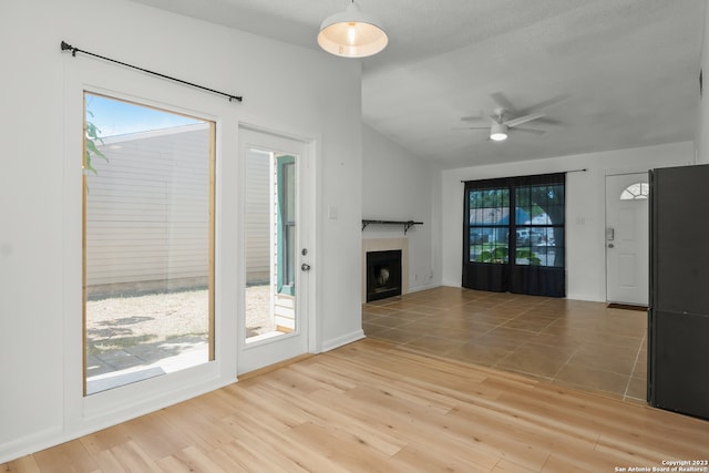 unfurnished living room featuring ceiling fan and light wood-type flooring