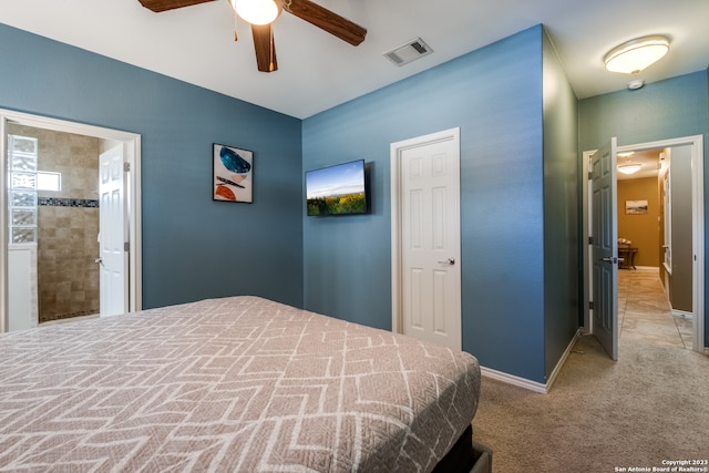 bedroom featuring connected bathroom, light colored carpet, and ceiling fan