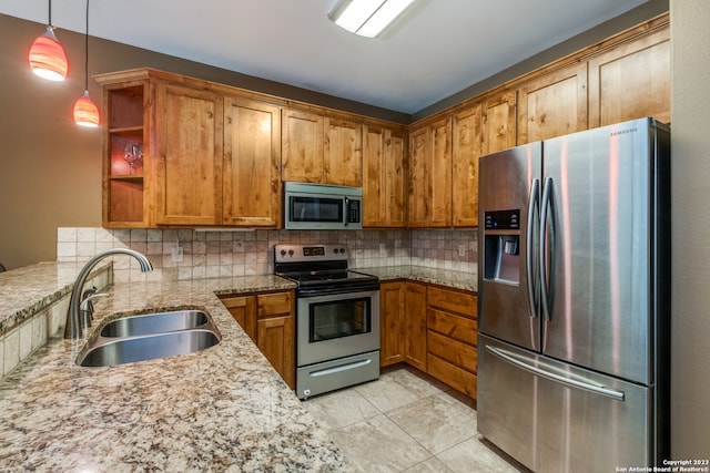 kitchen with decorative backsplash, sink, stainless steel appliances, and hanging light fixtures