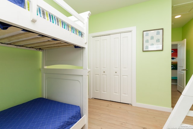 bedroom with light wood-type flooring and a closet