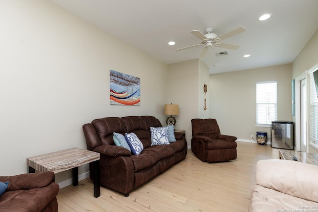 living room with light wood-type flooring and ceiling fan