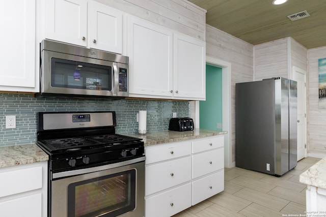 kitchen with white cabinets, light stone counters, and appliances with stainless steel finishes