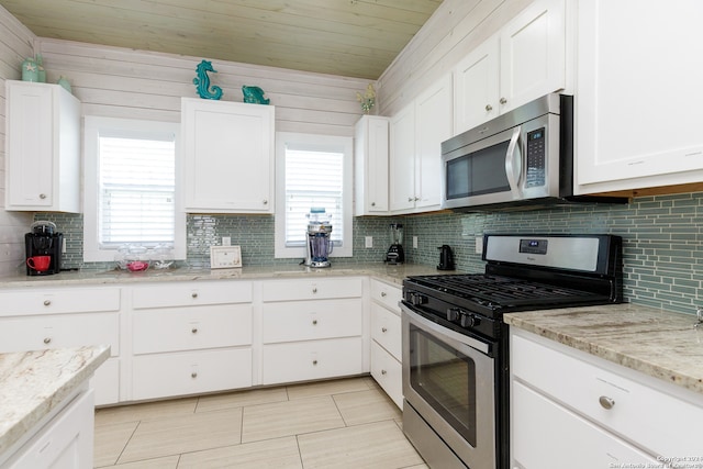 kitchen featuring appliances with stainless steel finishes, white cabinetry, and a healthy amount of sunlight