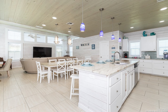 kitchen featuring pendant lighting, a center island with sink, ceiling fan, and sink