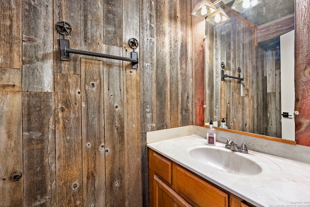 bathroom featuring vanity and wood walls