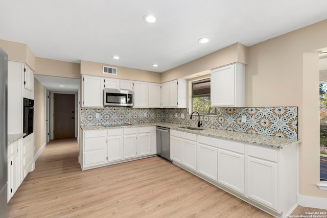 kitchen with sink, light hardwood / wood-style floors, white cabinetry, and black appliances