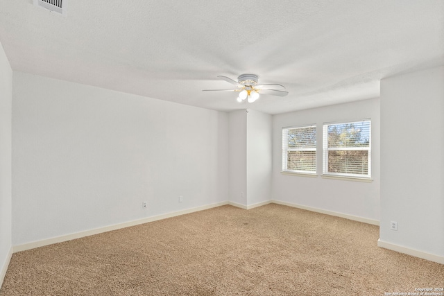 unfurnished room featuring carpet flooring, ceiling fan, and a textured ceiling