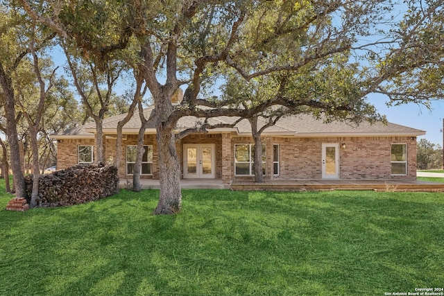 back of house featuring a lawn and french doors