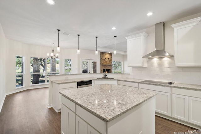 kitchen with dark wood-type flooring, white cabinets, wall chimney exhaust hood, a kitchen island, and kitchen peninsula