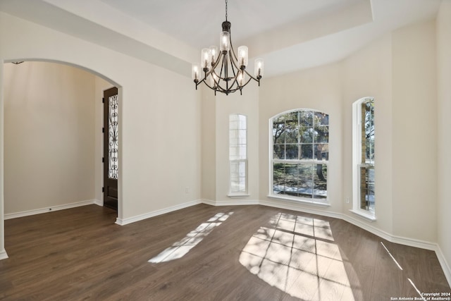 unfurnished room with a chandelier and dark hardwood / wood-style floors