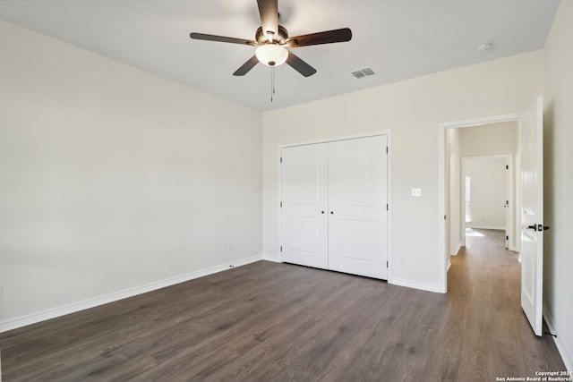 unfurnished bedroom with ceiling fan, a closet, and dark hardwood / wood-style floors