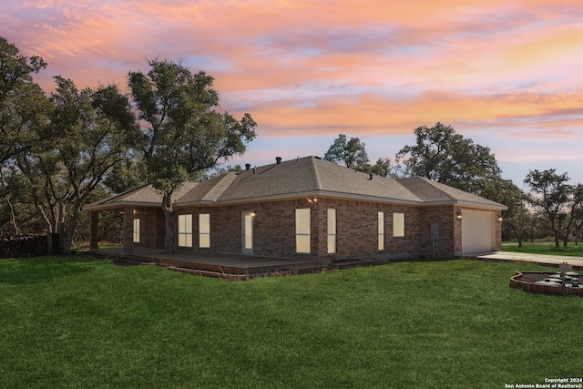 property exterior at dusk featuring a lawn and a garage