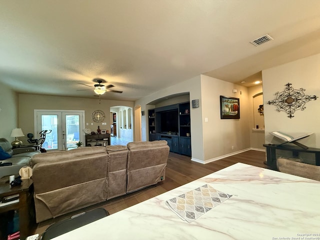 living room featuring ceiling fan, french doors, and dark hardwood / wood-style floors