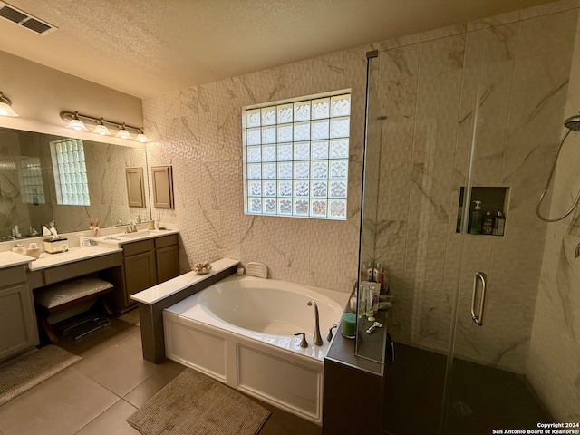 bathroom with vanity, a textured ceiling, tile patterned floors, and independent shower and bath