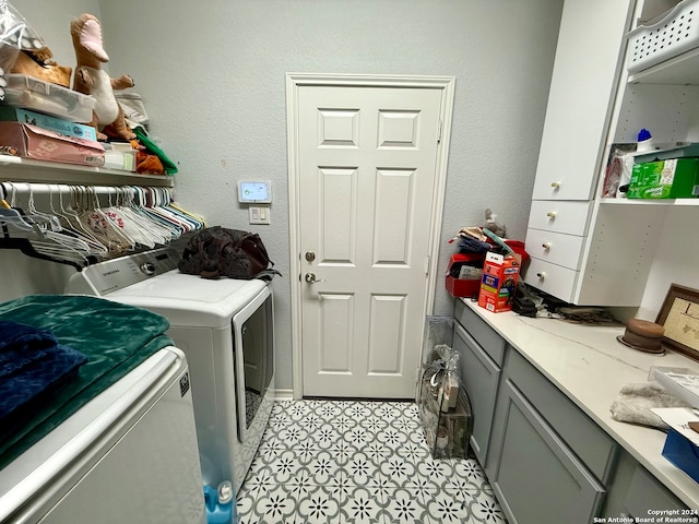 laundry area with washer and dryer, cabinets, and light tile patterned floors