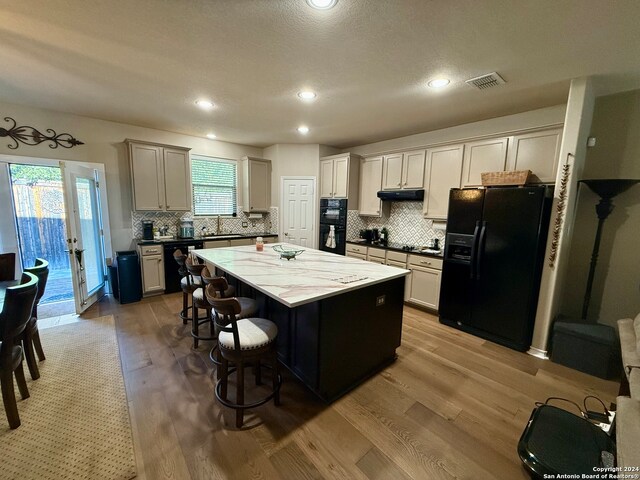 kitchen with plenty of natural light, black appliances, and light wood-type flooring