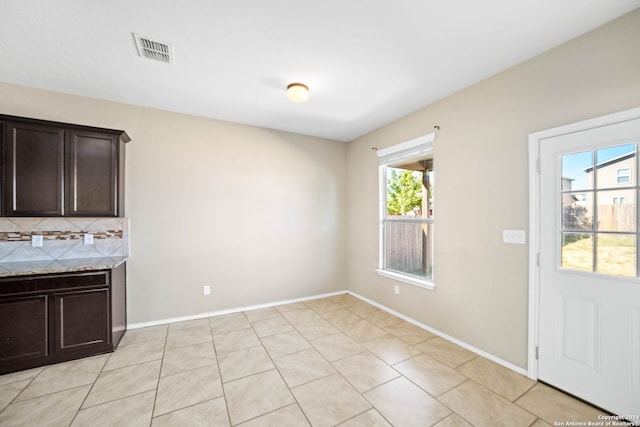 unfurnished dining area with light tile patterned floors and plenty of natural light